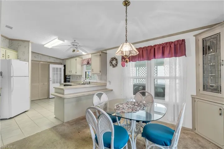 Tiled dining room with crown molding, sink, ceiling fan, and lofted ceiling