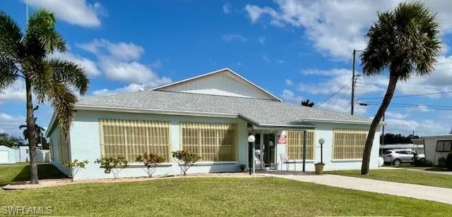 View of front of house featuring a front yard and a shingled roof