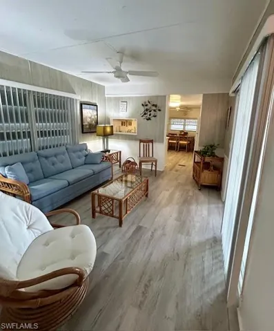 Living room with wood finished floors and a ceiling fan