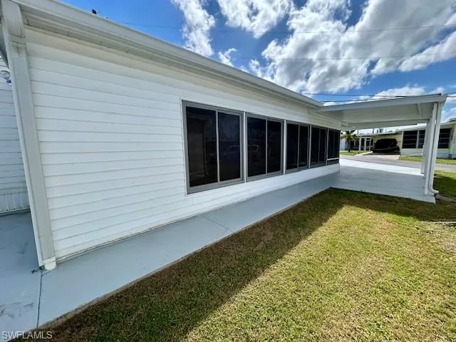 View of home's exterior featuring a yard and a sunroom