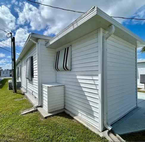 View of side of home with a yard