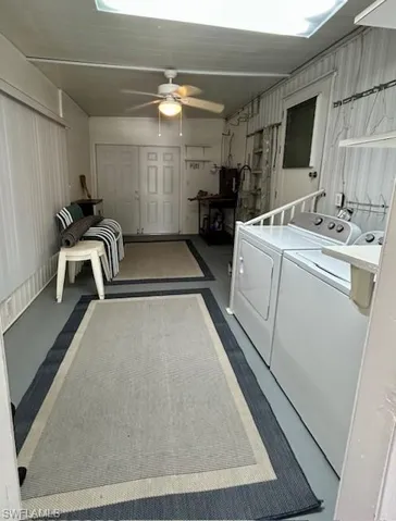 Laundry room with concrete flooring, ceiling fan, and washing machine and clothes dryer