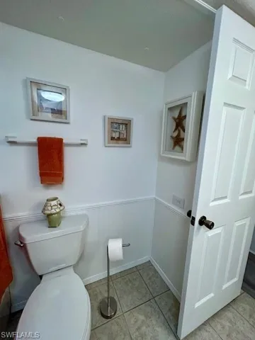 Bathroom featuring a wainscoted wall and light tile patterned floors