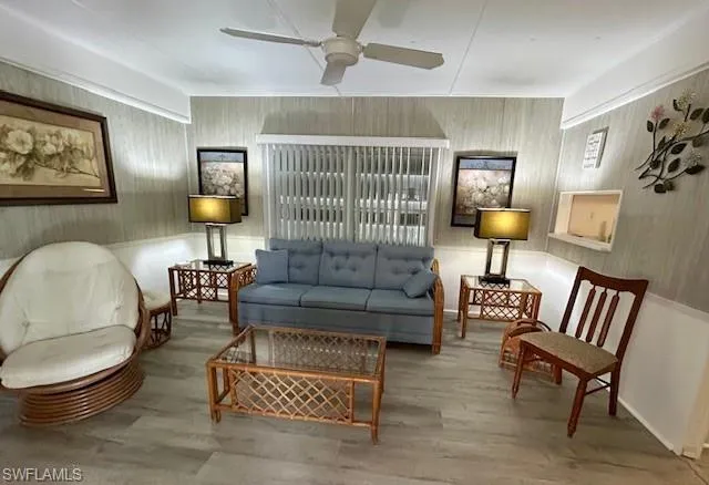 Living area with wood finished floors and a ceiling fan