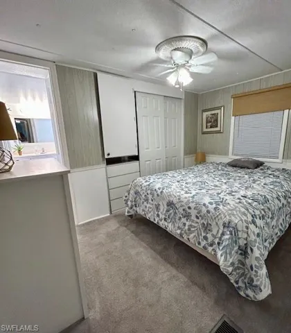 Carpeted bedroom featuring a closet, a textured ceiling, and a ceiling fan