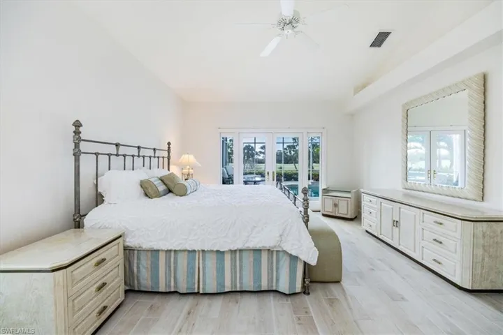 Bedroom featuring lofted ceiling, french doors, access to outside, light hardwood / wood-style flooring, and ceiling fan