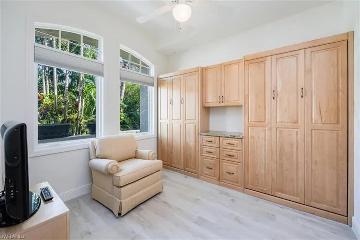 Sitting room with light wood-type flooring and ceiling fan