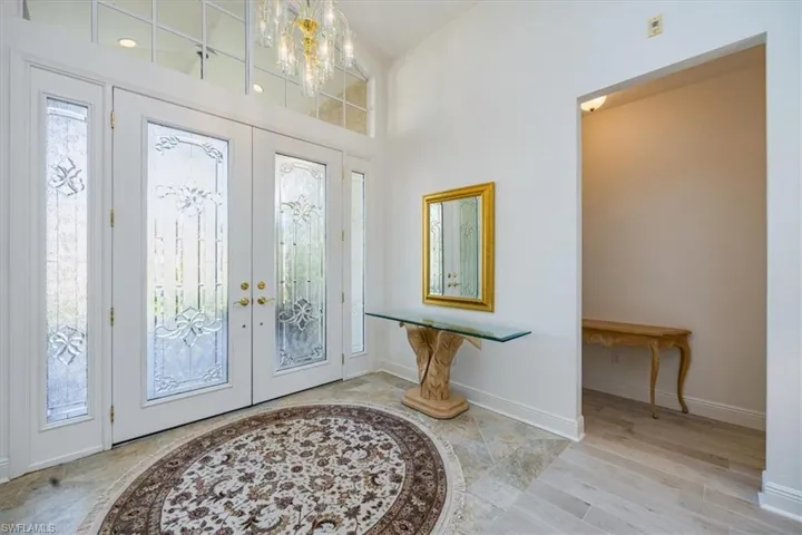 Foyer entrance featuring french doors, a notable chandelier, and light hardwood / wood-style floors