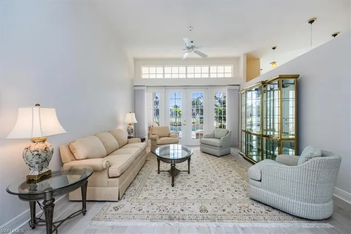 Living room featuring french doors, wood-type flooring, a high ceiling, and ceiling fan