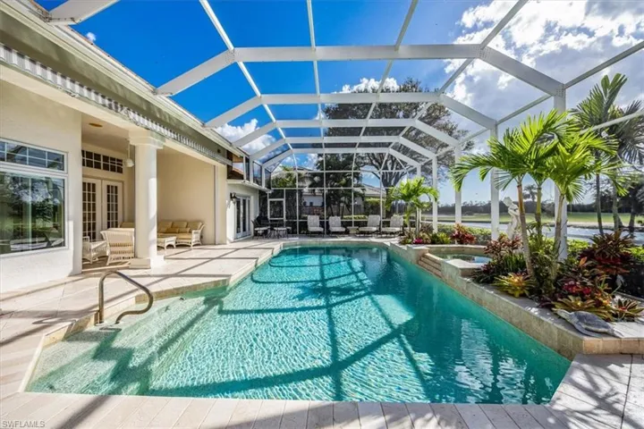 View of swimming pool with a patio area and glass enclosure