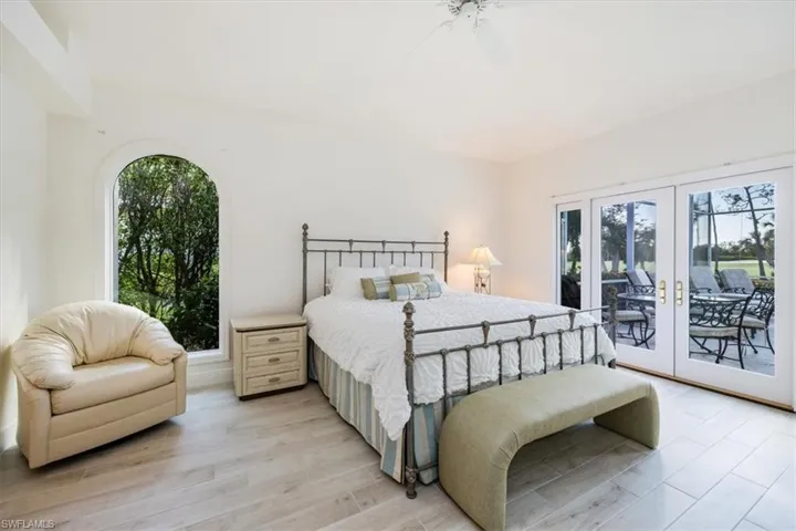 Bedroom featuring access to outside, french doors, light wood-type flooring, and ceiling fan