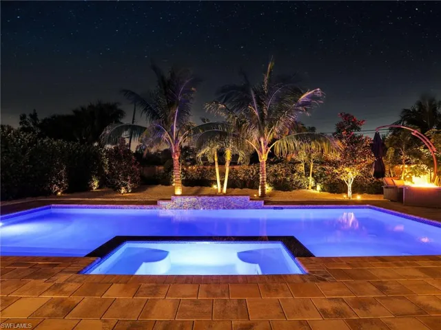 Pool at twilight with an in ground hot tub