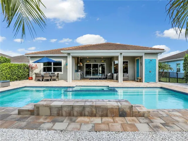View of swimming pool with ceiling fan and a patio area