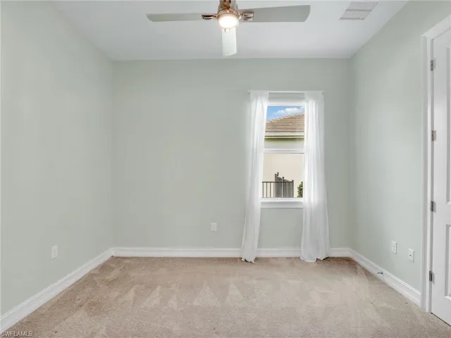 Carpeted empty room with ceiling fan