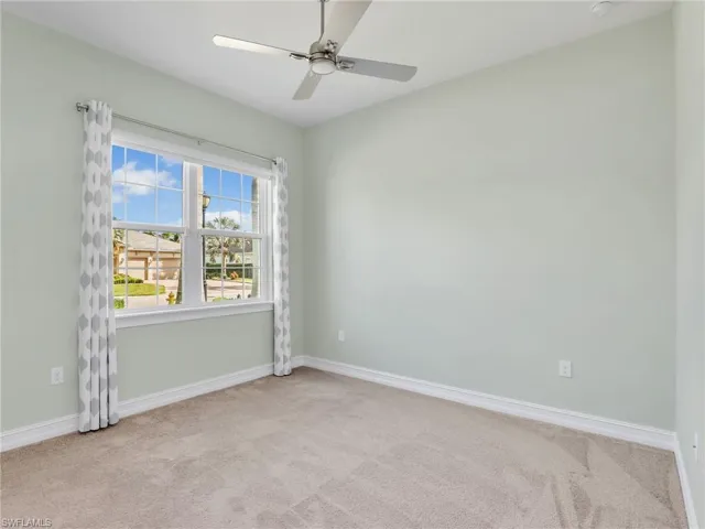 Unfurnished room featuring light carpet and ceiling fan