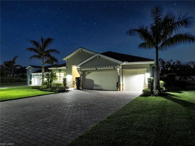 View of front of house featuring a lawn and a garage