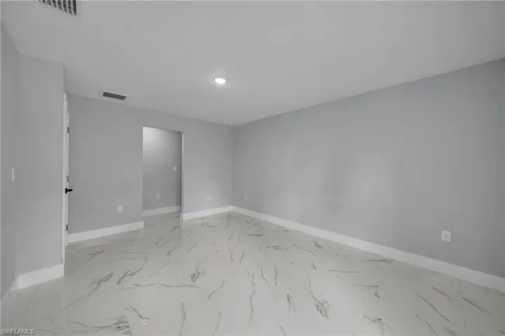 Unfurnished room with recessed lighting, marble finish floor, and visible vents