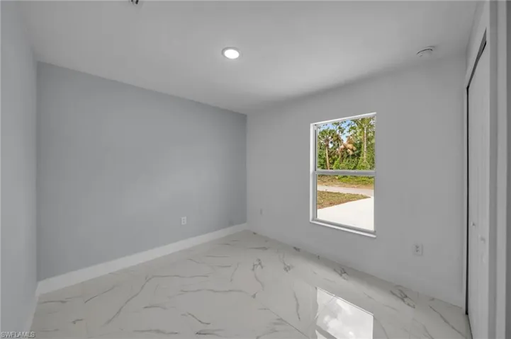Empty room featuring baseboards, recessed lighting, and marble finish floor