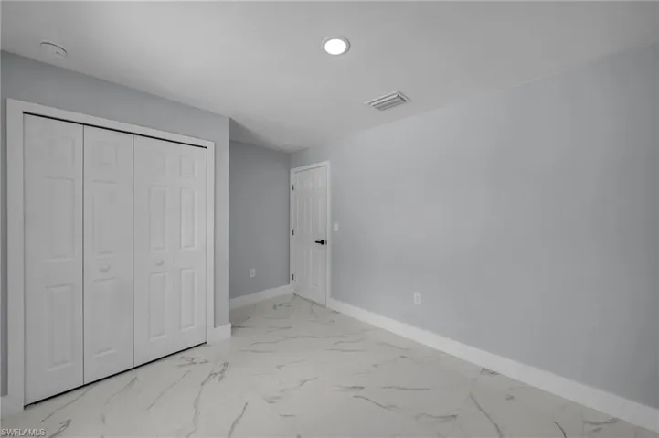 Unfurnished bedroom featuring visible vents, baseboards, a closet, marble finish floor, and recessed lighting