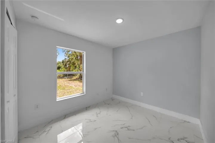 Unfurnished room featuring baseboards, recessed lighting, and marble finish floor