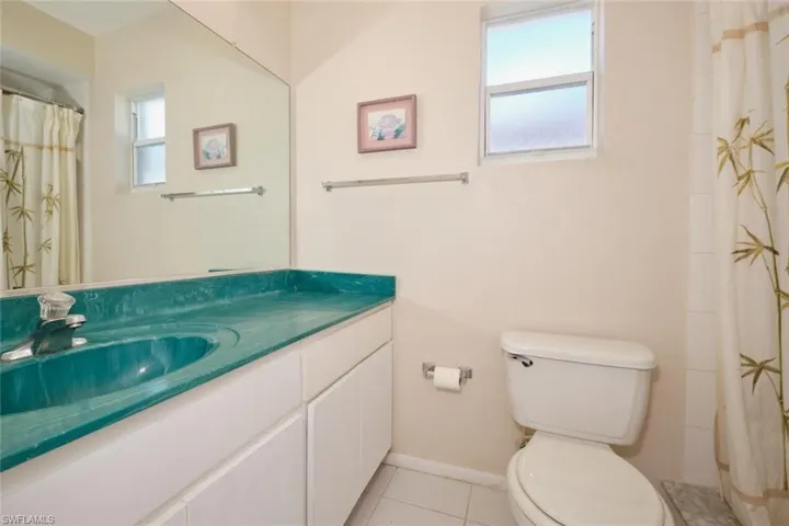 House - Primary Bath featuring vanity, tile patterned floors, natural light