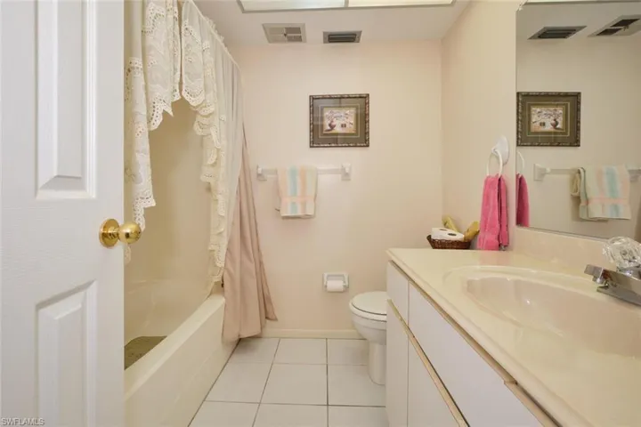 House - Guest Full bathroom with shower / bath combo, tile flooring