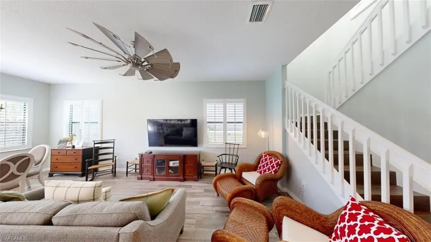 Living room with ceiling fan and hardwood / wood-style floors