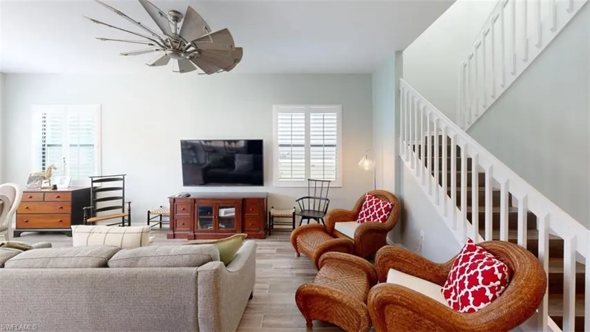 Living room with ceiling fan and hardwood / wood-style flooring