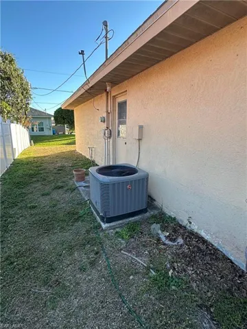 Exterior view of stucco siding and a central AC unit