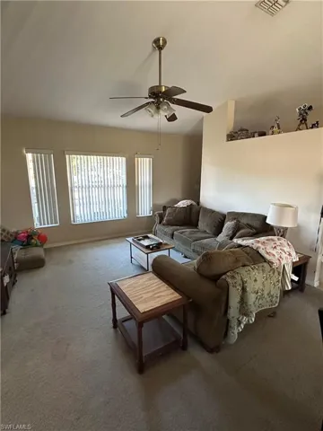 Living room with carpet and a ceiling fan