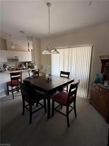 Dining room with ceiling fan and light carpet