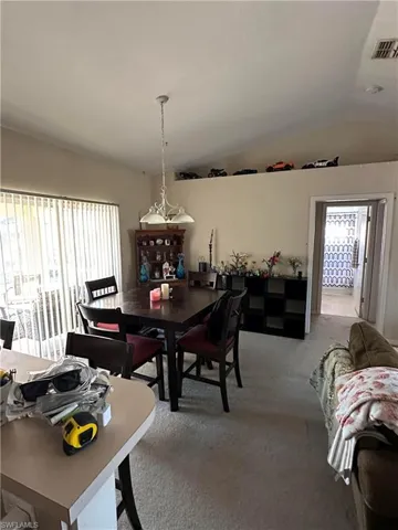 Dining area with carpet, vaulted ceiling, and healthy amount of natural light