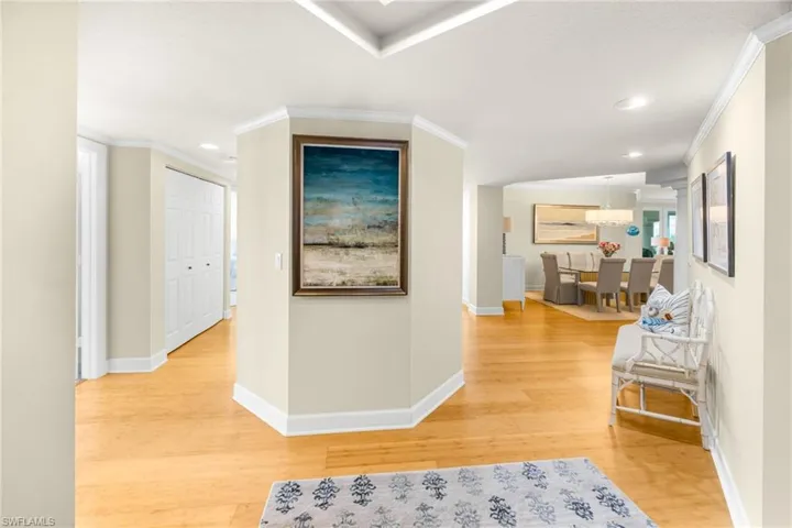Corridor featuring light wood-style floors, ornamental molding, and recessed lighting