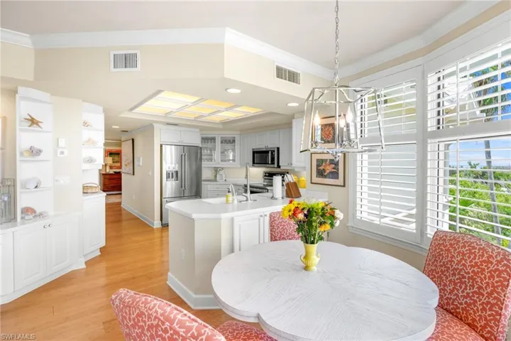 Dining area with light wood finished floors, ornamental molding, and hanging lights