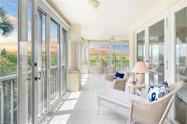 Sunroom with french doors, a balcony, and a ceiling fan