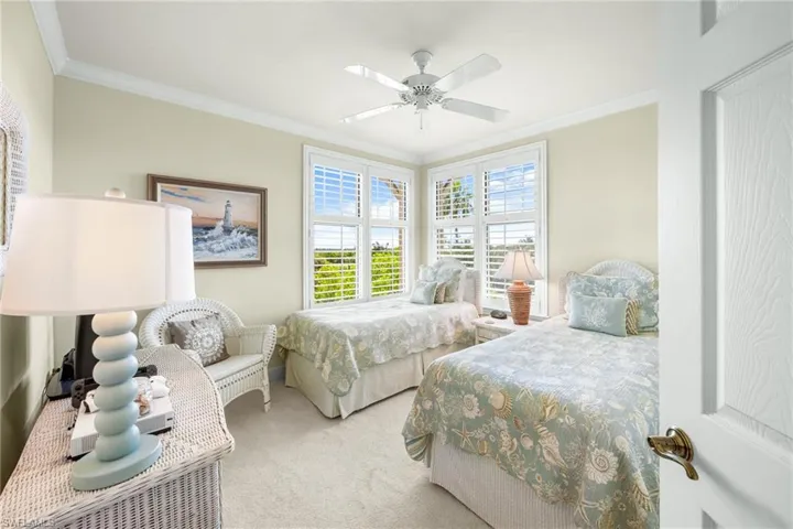 Bedroom with carpet floors, crown molding, and a ceiling fan