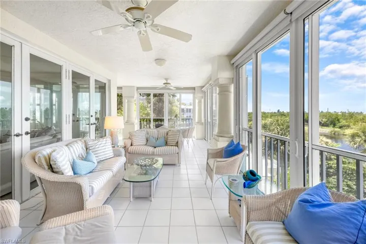 Sunroom with an outdoor living space, french doors, a ceiling fan, and a water view