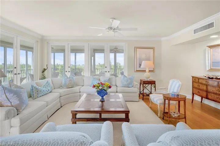 Living area featuring wood finished floors, ornamental molding, ceiling fan, and french doors