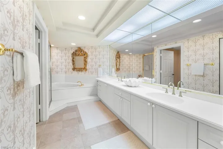 Full bath featuring wallpapered walls, double vanity, recessed lighting, a garden tub, and a stall shower