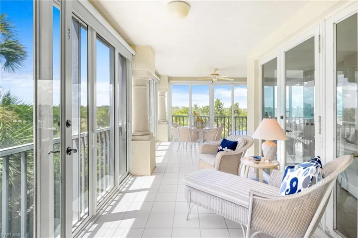 Sunroom / solarium with french doors, ceiling fan, and a balcony