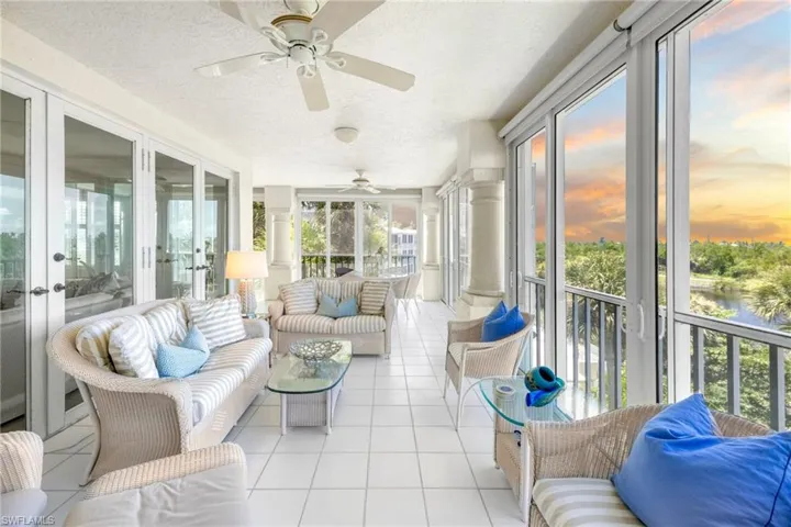 Sunroom / solarium featuring outdoor furniture, french doors, ceiling fan, and a water view