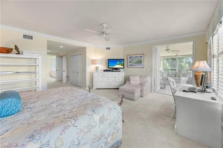 Bedroom featuring light colored carpet, crown molding, a closet, access to exterior, and a ceiling fan