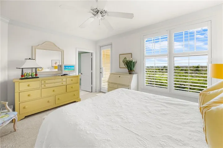 Bedroom featuring ceiling fan, light colored carpet, and ornamental molding