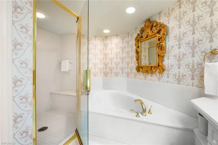 Full bathroom with a stall shower, wallpapered walls, a garden tub, recessed lighting, and vanity