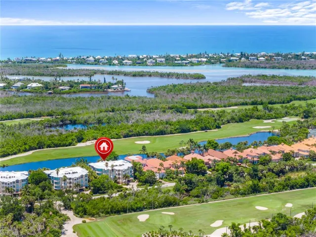 Aerial view of property and surrounding area with a local golf course and a nearby body of water