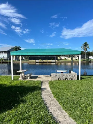 Dock area featuring a lawn and a water view