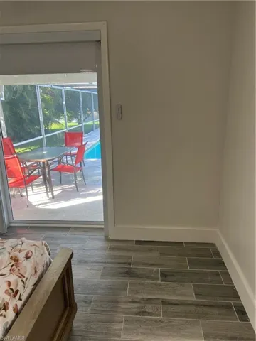 Doorway to outside featuring wood finish floors and baseboards