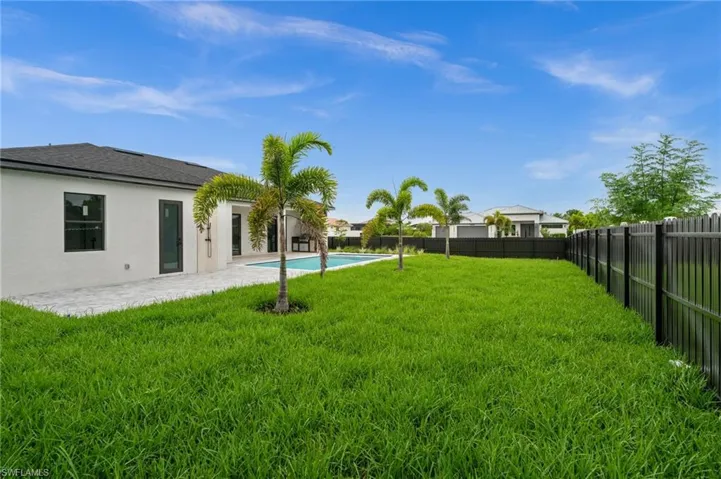 Expansive green lawn framed by a black metal fence