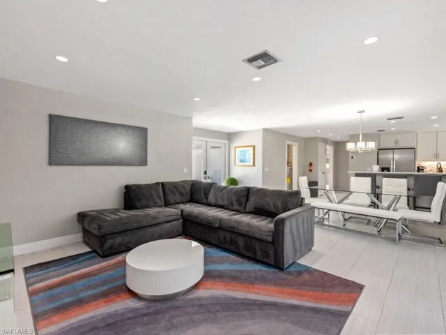 Living room with recessed lighting, light tile patterned floors, and a chandelier