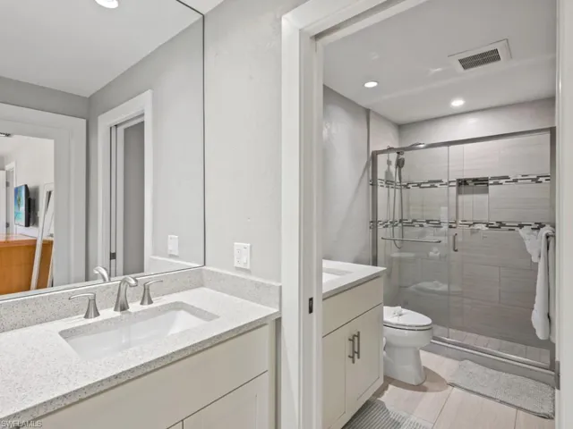 Bathroom with vanity, a stall shower, and recessed lighting